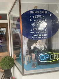 Readings By Cristine shop window displaying a psychic reading sign, amethyst geodes and an open light
